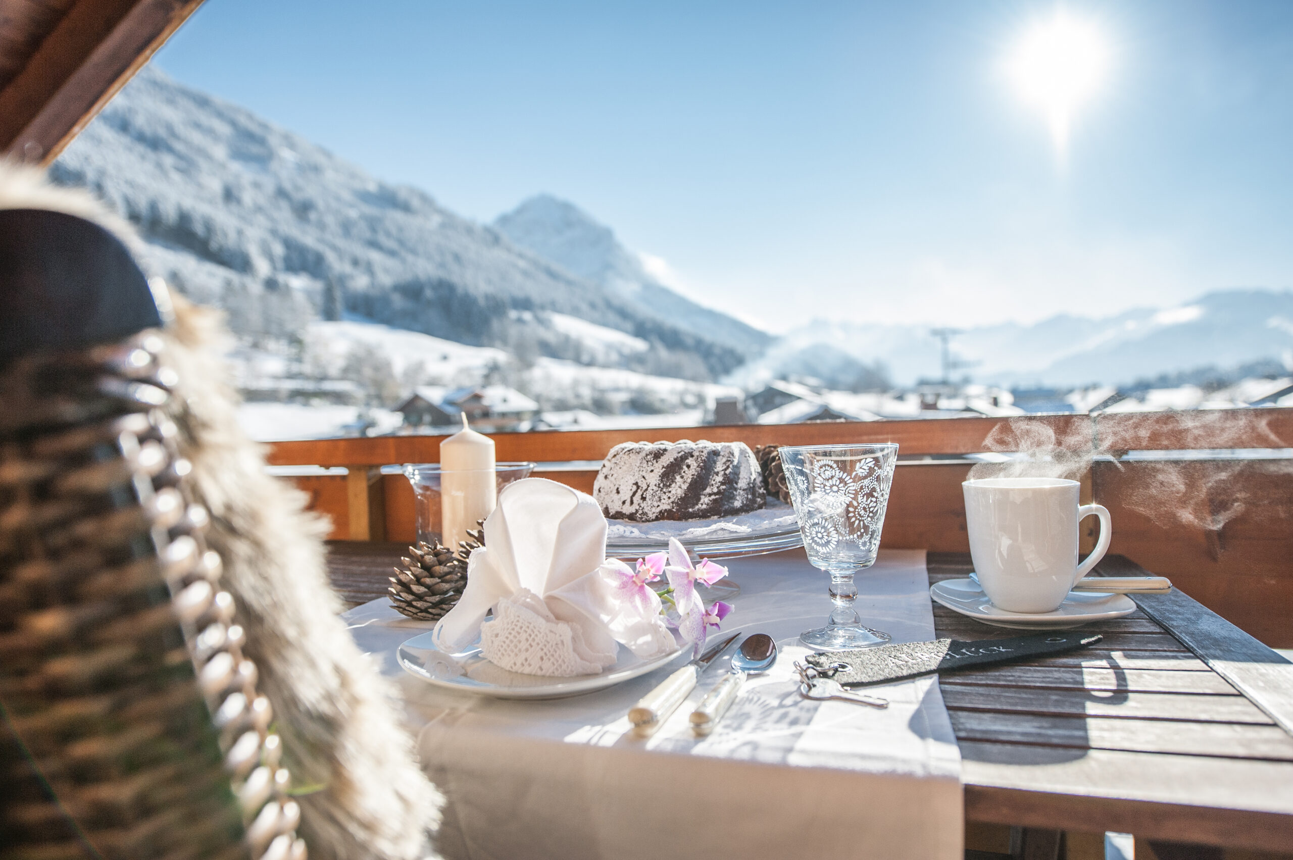 gedeckter Esstisch auf Balkon im Winter bei Sonnenschein